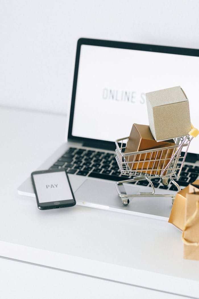 about-img Mini shopping cart on laptop symbolizing online shopping and e-commerce transactions.