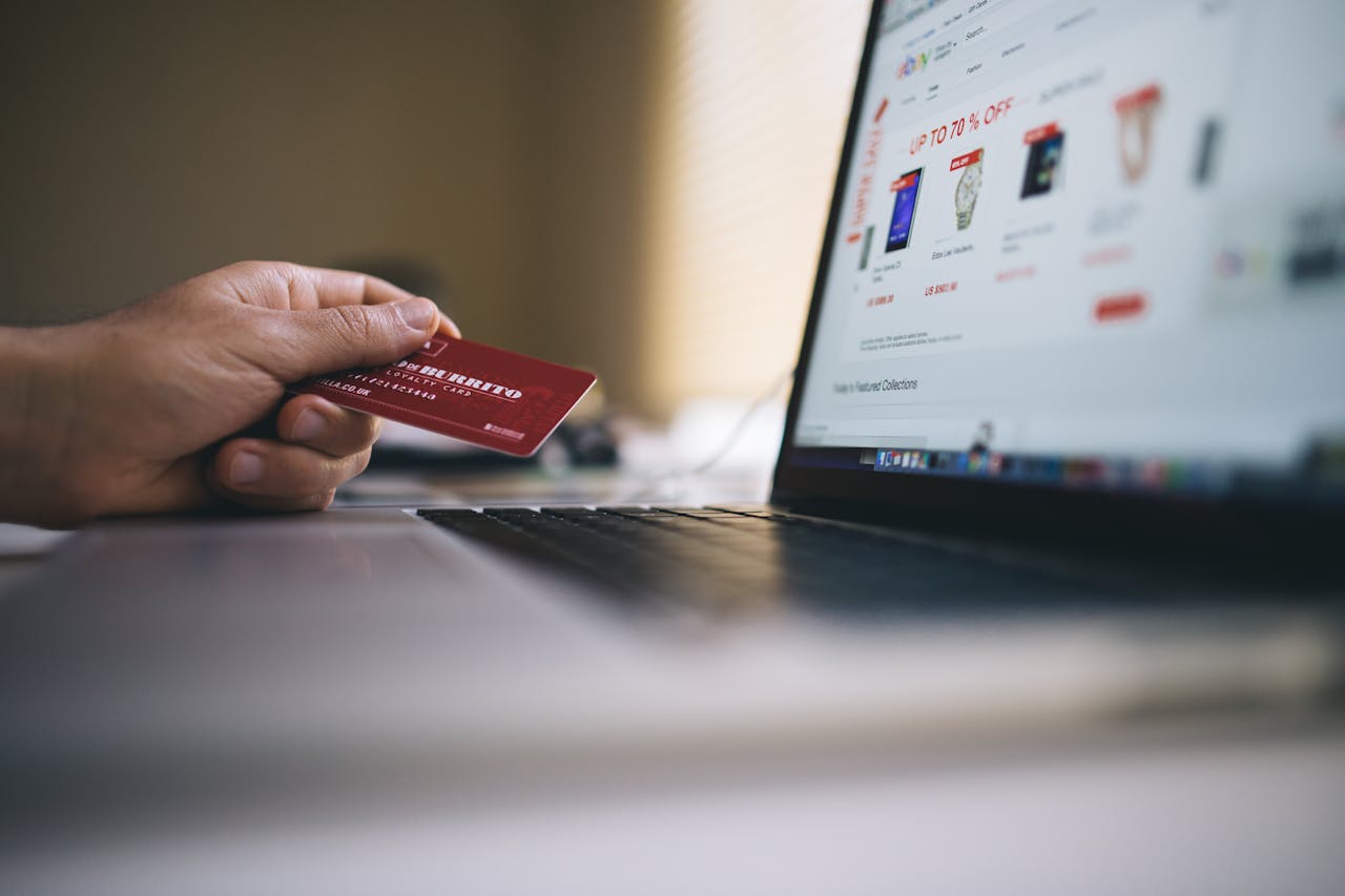 social-feed-img-03 Person holding a credit card while shopping online on a laptop, indicating ecommerce transactions.